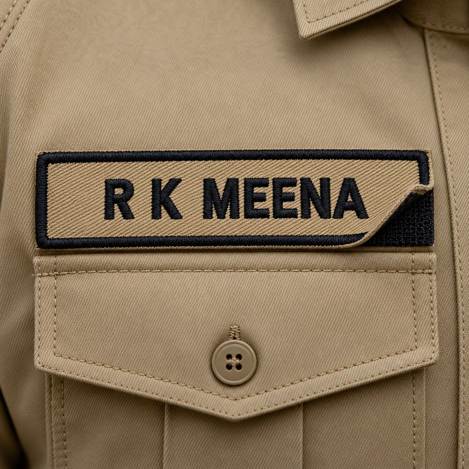 Khaki embroidered police name plate with black lettering and velcro back